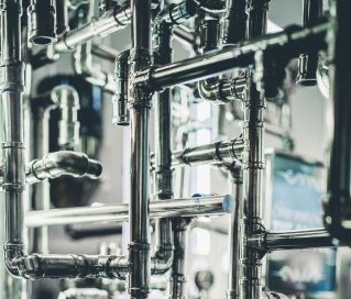 Close-up of complex stainless steel pipes in an industrial setting, showcasing modern engineering.